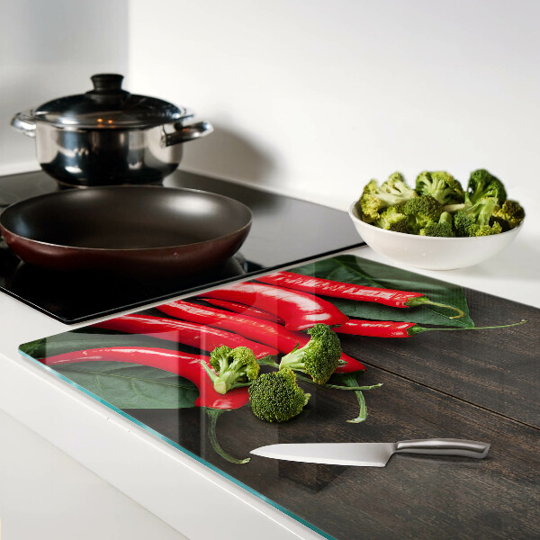 Glas-Schneidebrett mit Chilischoten auf Holzgrund