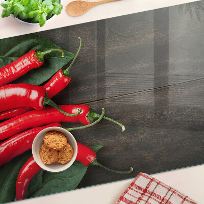 Glas-Schneidebrett mit Chilischoten auf Holzgrund