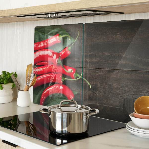 Glas-Schneidebrett mit Chilischoten auf Holzgrund