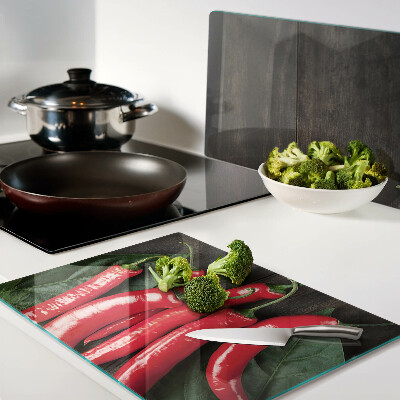 Glas-Schneidebrett mit Chilischoten auf Holzgrund