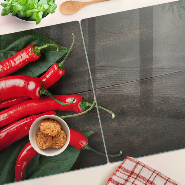 Glas-Schneidebrett mit Chilischoten auf Holzgrund