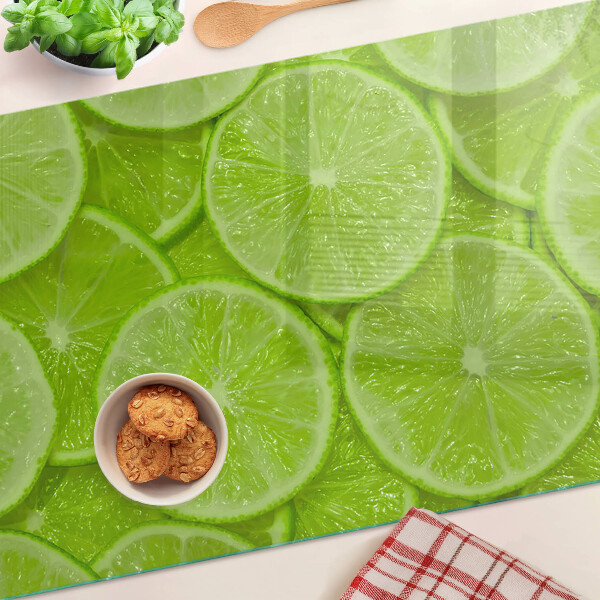 Schneidebrett mit Motiv von Limettenscheiben auf grünem Hintergrund