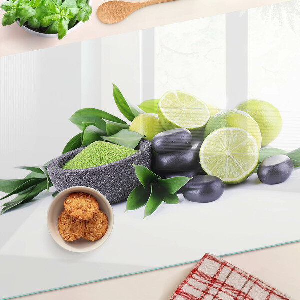 Glas-Schneidebrett mit Motiv aus Zitronen und Trauben auf grünem Hintergrund