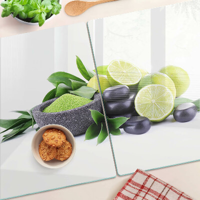 Glas schneidebrett Zitronen und Trauben auf grünem Hintergrund