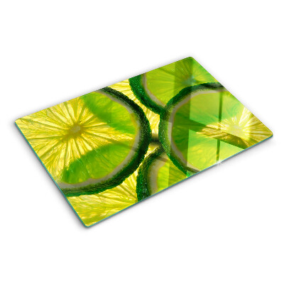 Schneidebrett mit Limettenscheiben auf grünem Hintergrund