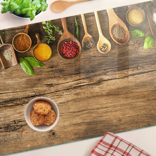 Schneidebrett mit Motiv aus Gewürzen und Kräutern auf Holzgrund