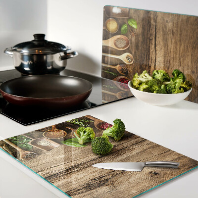 Schneidebrett mit Motiv aus Gewürzen und Kräutern auf Holzgrund