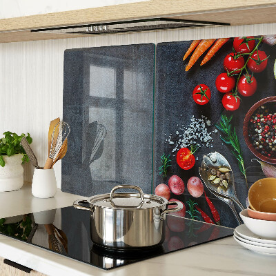 Glas-Schneidebrett mit Motiv von Gemüse und Gewürzen auf dunklem Hintergrund