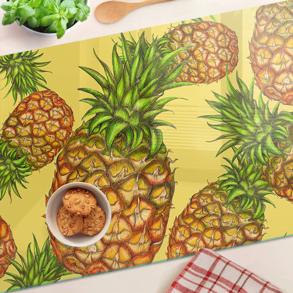 Schneidebrett mit Ananas-Motiv vor gelbem Hintergrund