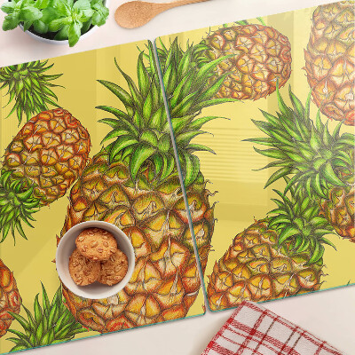 Schneidebrett mit Ananas-Motiv vor gelbem Hintergrund