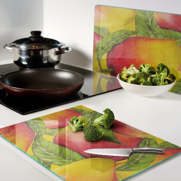 Glas-Schneidebrett mit Paprika vor grünem Blätterhintergrund