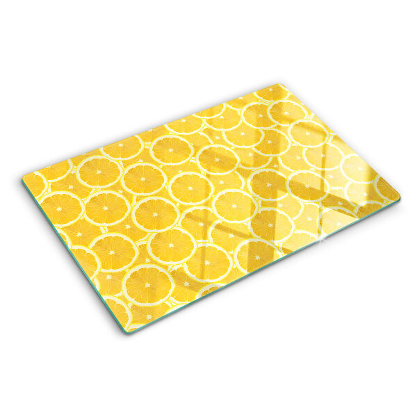 Schneidebrett mit Motiv aus Zitronenscheiben vor gelbem Hintergrund