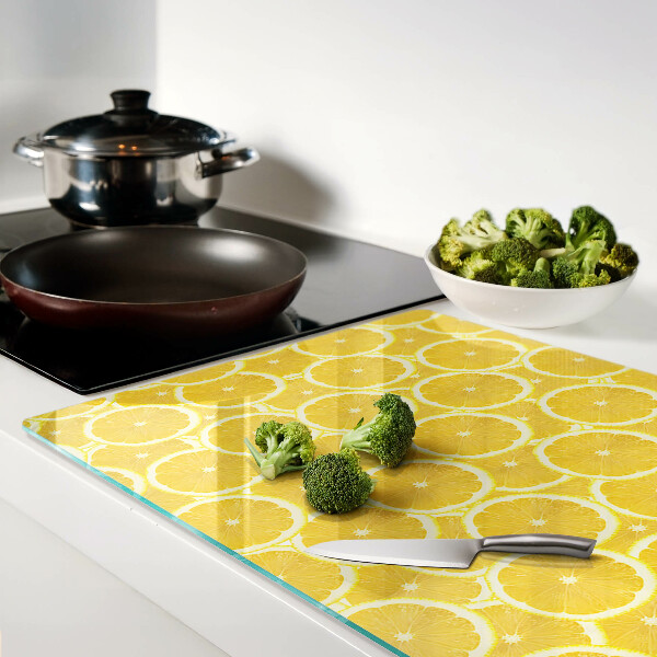 Schneidebrett mit Motiv aus Zitronenscheiben vor gelbem Hintergrund