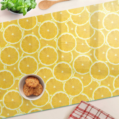 Schneidebrett mit Motiv aus Zitronenscheiben vor gelbem Hintergrund