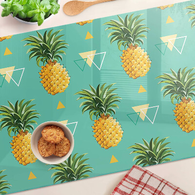 Glas-Schneidebrett mit dem Motiv einer Ananas auf türkisfarbenem Hintergrund