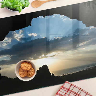 Glas-Schneidebrett mit Motiv eines Sonnenuntergangs hinter Wolken