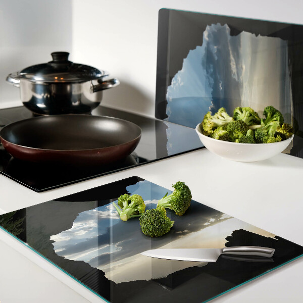 Glas-Schneidebrett mit Motiv eines Sonnenuntergangs hinter Wolken