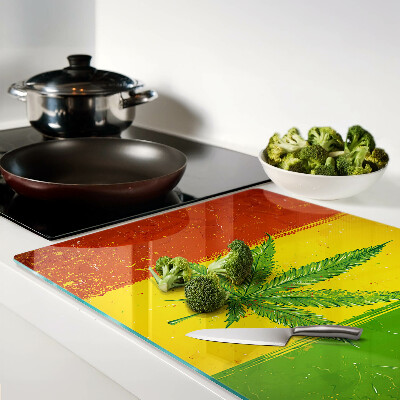 Glas-Schneidebrett mit Cannabisblatt auf farbigem Hintergrund