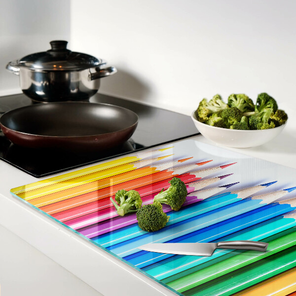 Schneidebrett Glas mit farbigen Stiften nebeneinander angeordnet