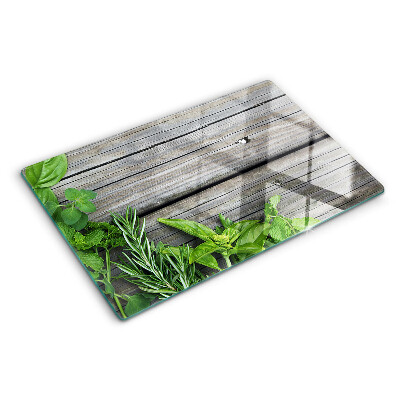 Glas-Schneidebrett mit Motiv grüner Kräuter auf Holzuntergrund