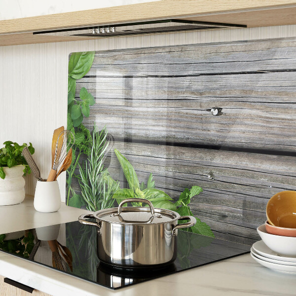 Glas-Schneidebrett mit Motiv grüner Kräuter auf Holzuntergrund