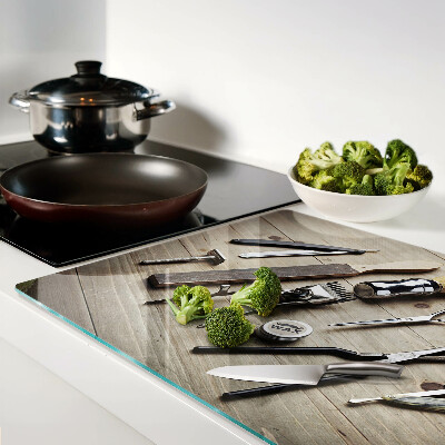 Glas-Schneidebrett mit Friseurwerkzeugen auf Holzoptik