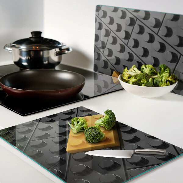 Glas-Schneidebrett mit Motiv aus LEGO-Steinen auf schwarzem Hintergrund