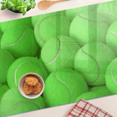 Schneidebrett mit Motiv von Tennisbällen auf grünem Hintergrund