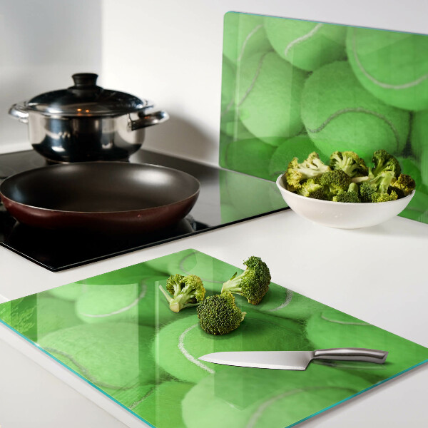 Schneidebrett mit Motiv von Tennisbällen auf grünem Hintergrund