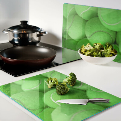 Schneidebrett Tennisbälle auf grünem Hintergrund