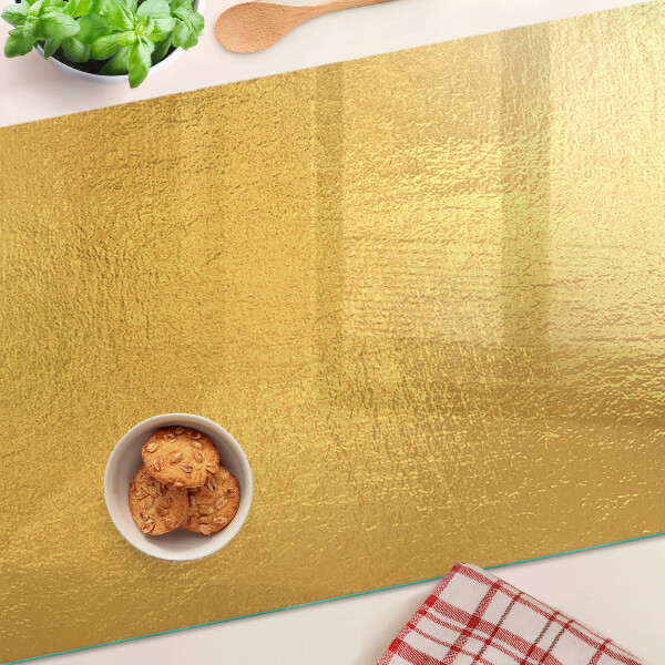 Glas-Schneidebrett mit goldfarbener, spiegelnder Oberfläche