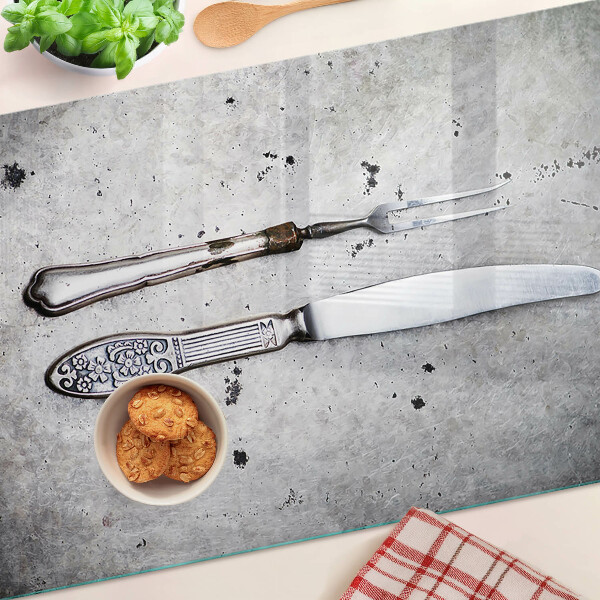 Schneidebrett mit Besteckmotiv auf Betongrund