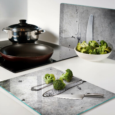 Schneidebrett mit Besteckmotiv auf Betongrund