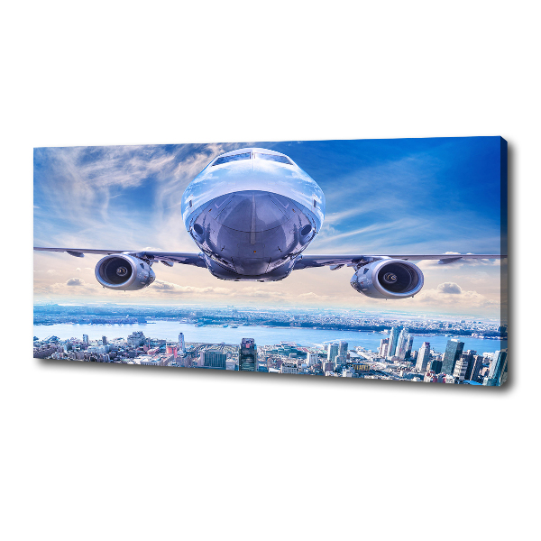 Bild auf leinwand Ein Flugzeug über der Stadt