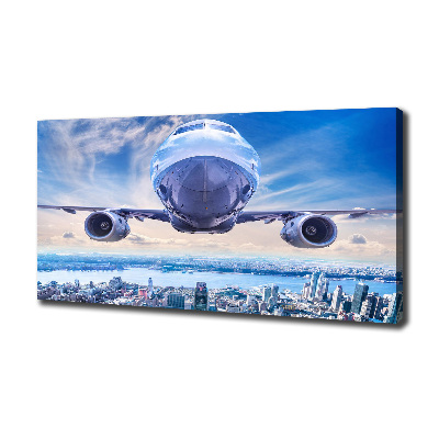 Bild auf leinwand Ein Flugzeug über der Stadt