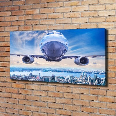 Bild auf leinwand Ein Flugzeug über der Stadt