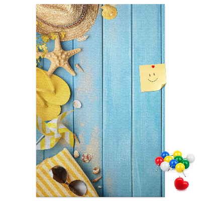 Pinnwand mit Sommeraccessoires vor blauem Holzgrund