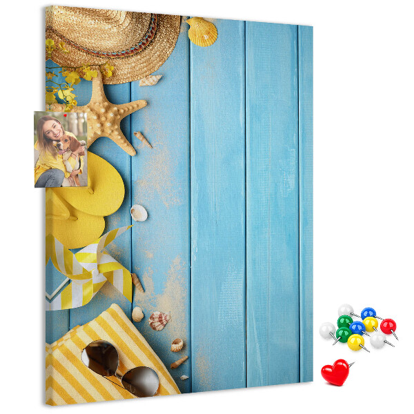 Pinnwand mit Sommeraccessoires vor blauem Holzgrund
