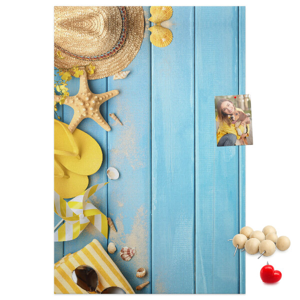 Pinnwand mit Sommeraccessoires vor blauem Holzgrund