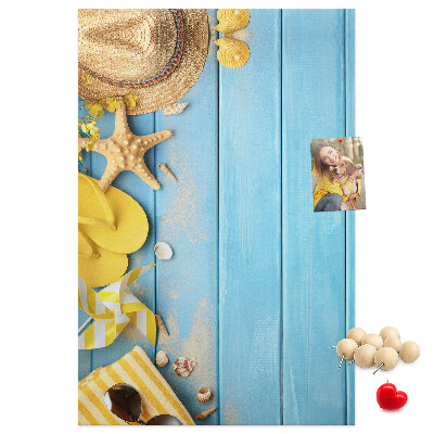Pinnwand mit Sommeraccessoires vor blauem Holzgrund