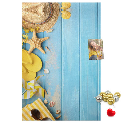 Pinnwand mit Sommeraccessoires vor blauem Holzgrund