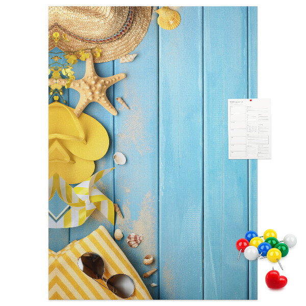 Pinnwand mit Sommeraccessoires vor blauem Holzgrund