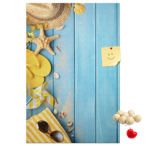 Pinnwand mit Sommeraccessoires vor blauem Holzgrund