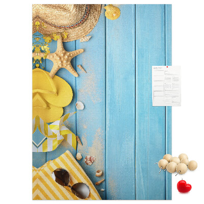 Pinnwand mit Sommeraccessoires vor blauem Holzgrund