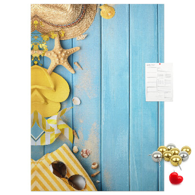 Pinnwand mit Sommeraccessoires vor blauem Holzgrund