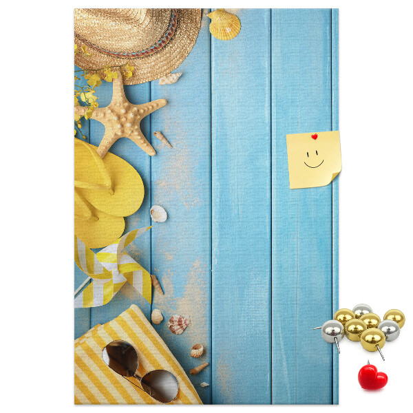 Pinnwand mit Sommeraccessoires vor blauem Holzgrund