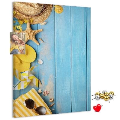 Pinnwand mit Sommeraccessoires vor blauem Holzgrund