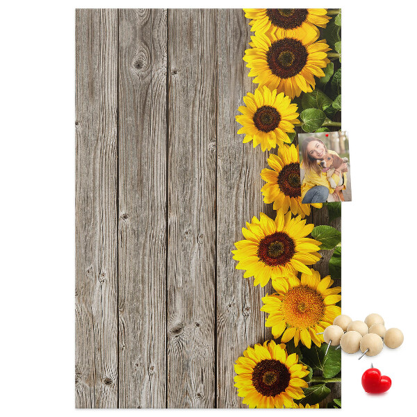 Kork-Pinnwand mit Sonnenblumen auf Holzbrett-Hintergrund