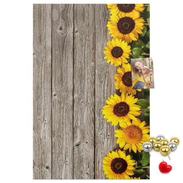Kork-Pinnwand mit Sonnenblumen auf Holzbrett-Hintergrund