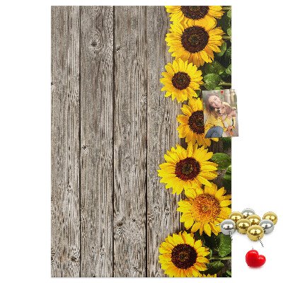 Kork-Pinnwand mit Sonnenblumen auf Holzbrett-Hintergrund